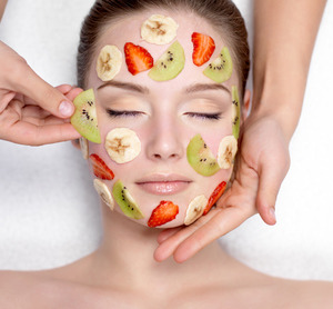 Cosmetician Doing Fruit Mask On A Face Of  Woman